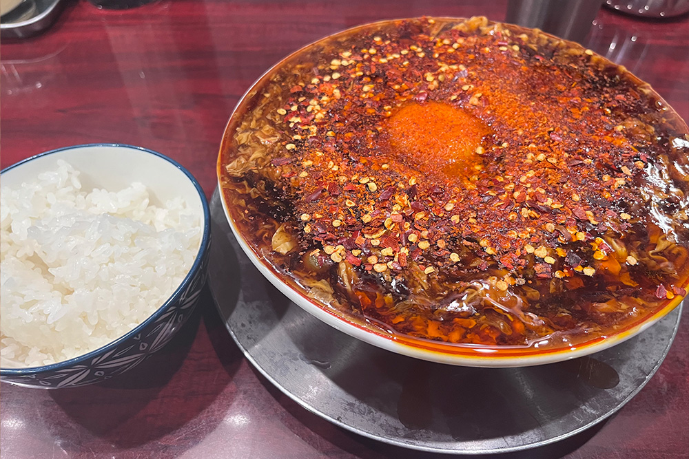 中華そば 辻 のヂャン麺。唐辛子をたっぷりのせた赤いスープの一杯とごはん